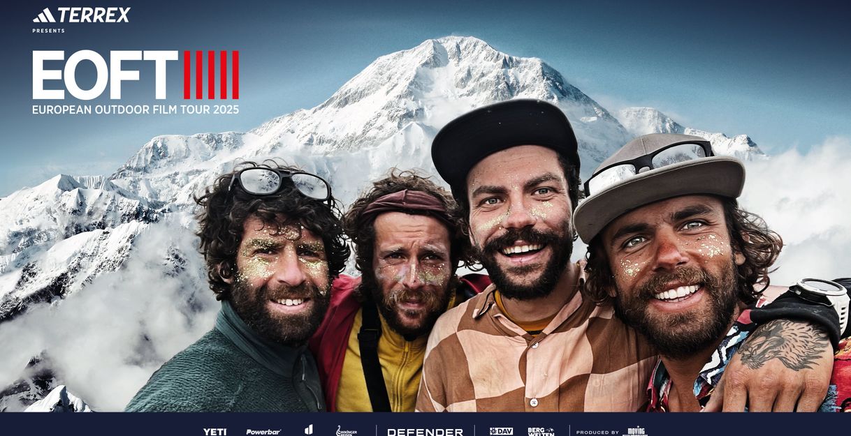 Vier Männer mit Glitzer im Gesicht vor einer schneebedeckten Gipfelkette