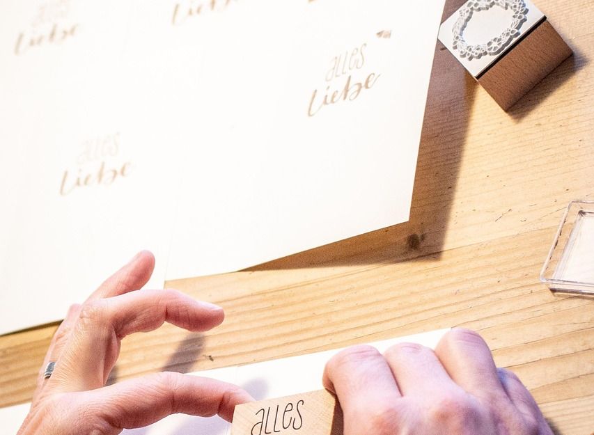 Person stempelt "Alles Liebe" auf Karten.