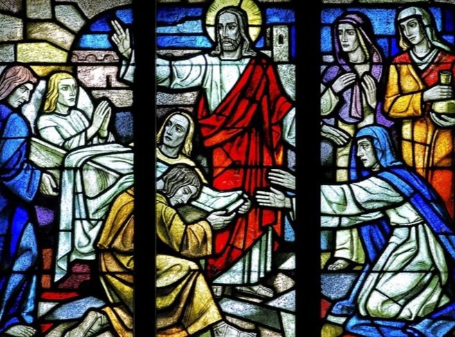 Buntglasfenster mit biblischer Szene in einer Kirche.