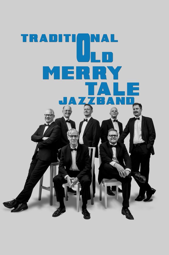 Gruppe von sieben Männern in Anzügen, die vor einem Schriftzug "Traditional Old Merry Tale Jazzband" posieren.