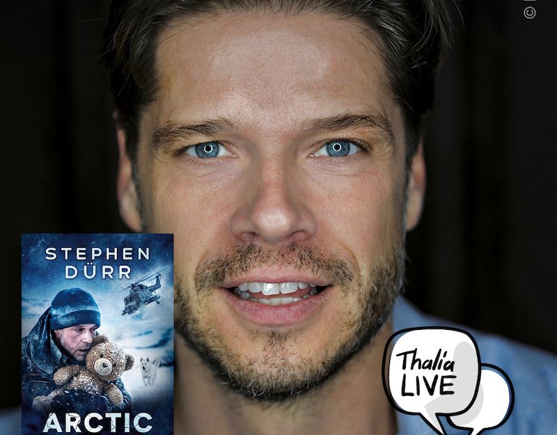 Porträt eines Mannes mit Bart und blauen Augen in einem blauen Hemd.