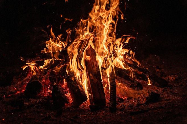 Ein loderndes Lagerfeuer in der Dunkelheit.