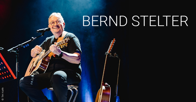 Bernd Stelter spielt Gitarre auf der Bühne.