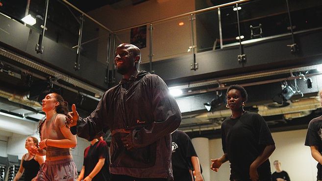 Menschen tanzen in einem Studio mit moderner Einrichtung.