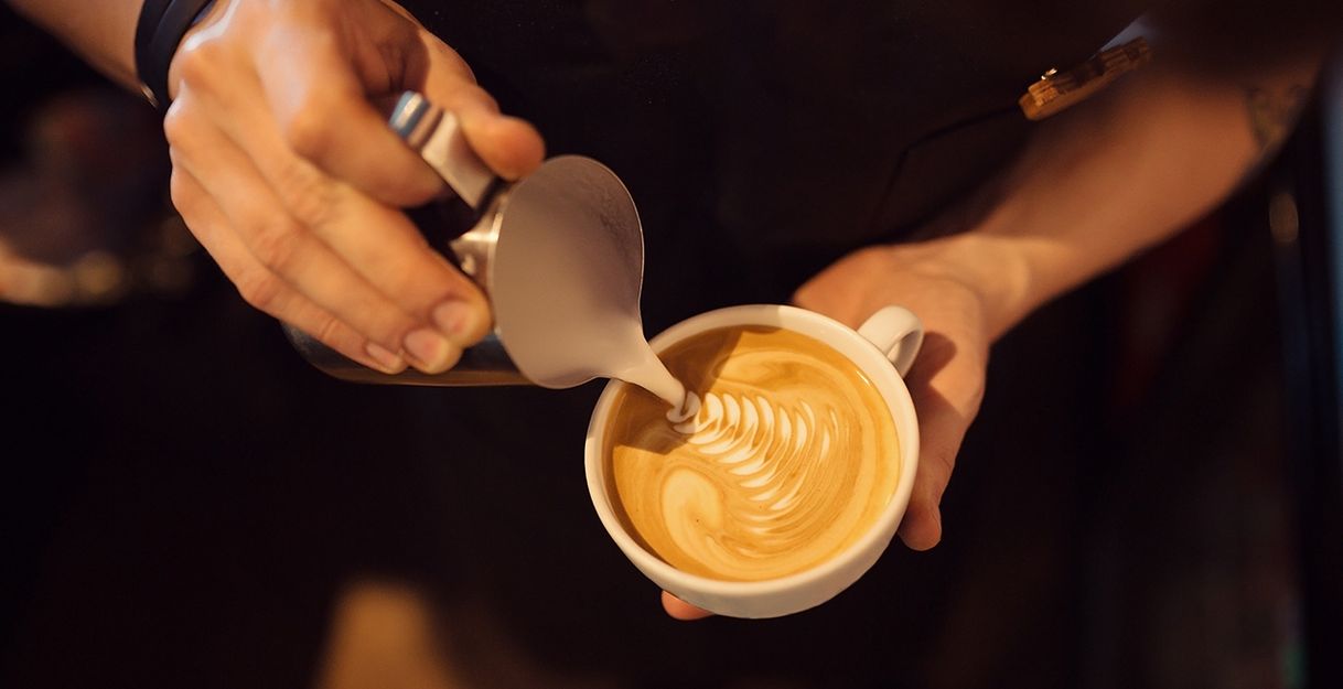 Barista zeichnet Kaffee Latte Art Figur