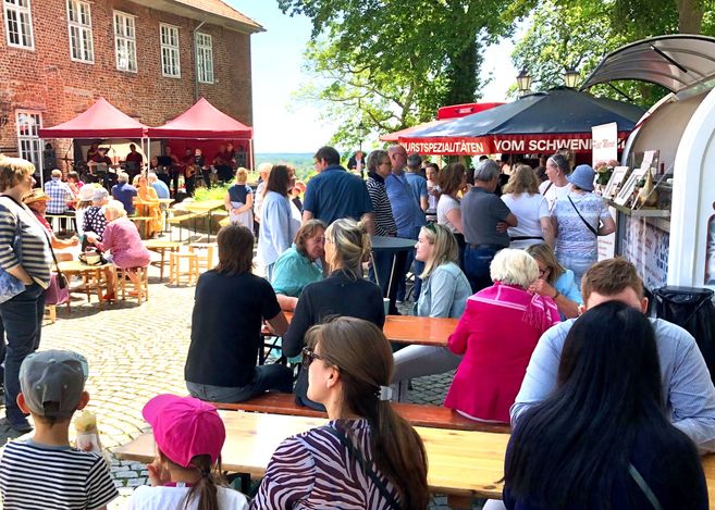 Menschen genießen ein Fest im Freien mit Essensständen und Livemusik in Lauenburg.