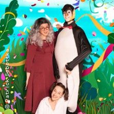 Drei Personen in bunten Kostümen vor einem farbenfrohen Hintergrund mit Konfetti und Pflanzen.