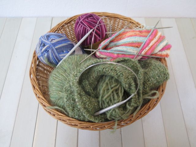 Wolle und Stricknadeln in einem Korb