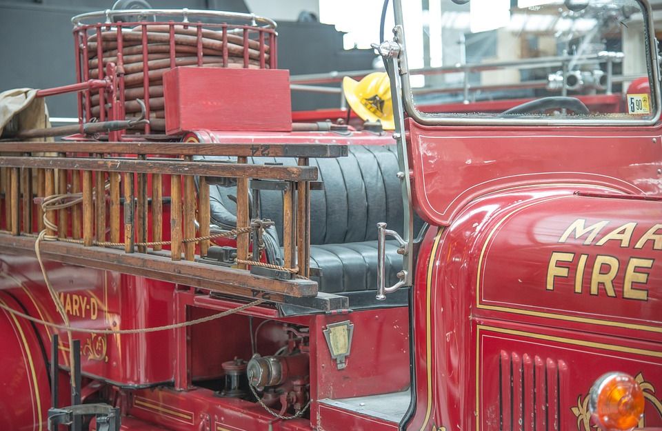 Altes rotes Feuerwehrauto mit Schläuchen und Leiter.