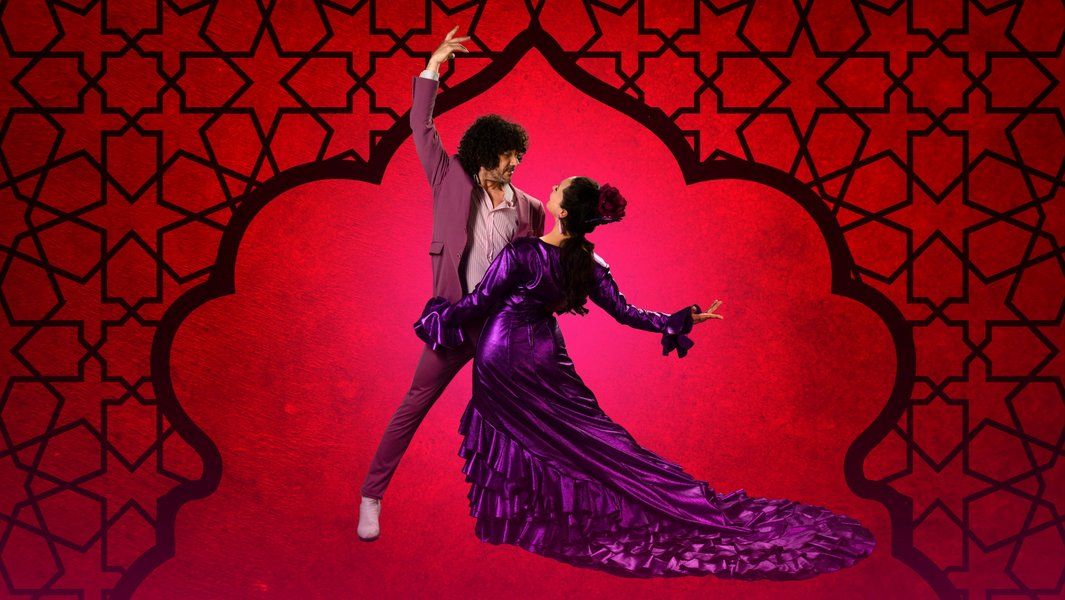 Ein Paar tanzt Flamenco vor einem roten, gemusterten Hintergrund.