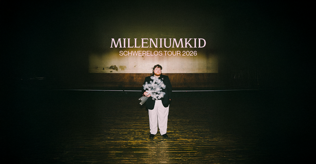 Person steht auf einer Bühne mit einem Schild im Hintergrund, das "Milleniumkid - Schwerelos Tour 2026" zeigt.