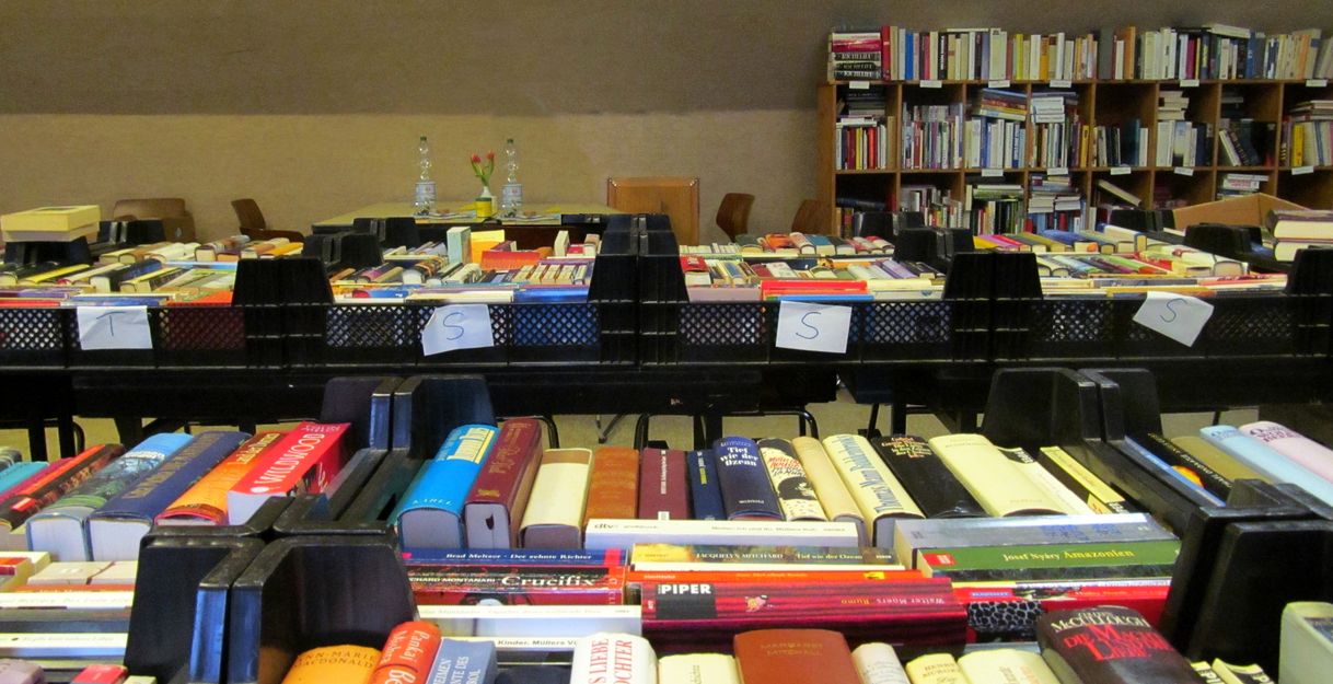 Bücher in Kisten auf einem Tisch in einem Gemeindehaus.