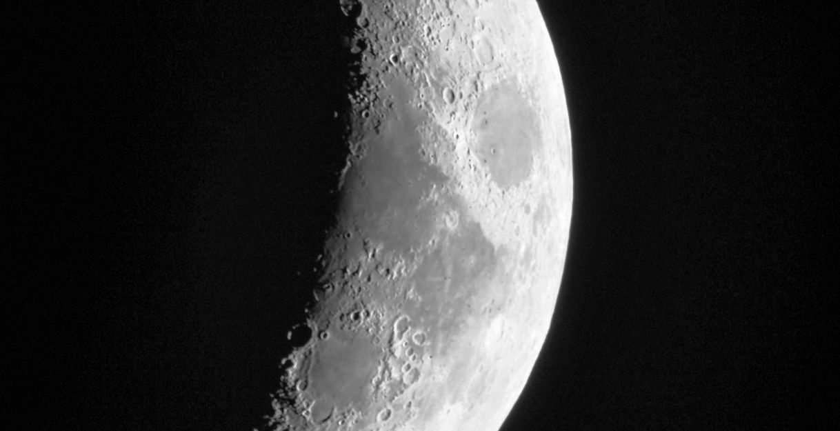 Nahaufnahme eines Halbmondes mit sichtbaren Kratern und Details auf der Mondoberfläche.