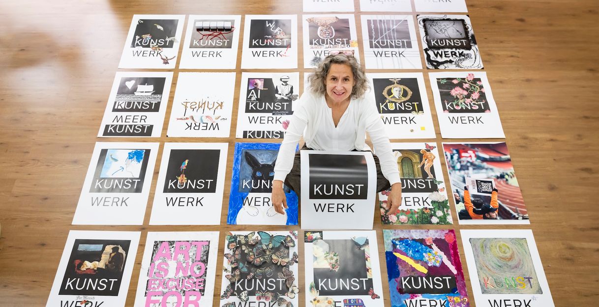 Ulrike Bals mit Blanko-Plakat in mitten der Kunstwerke