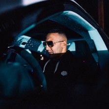 Person mit Sonnenbrille sitzt in einem Auto.
