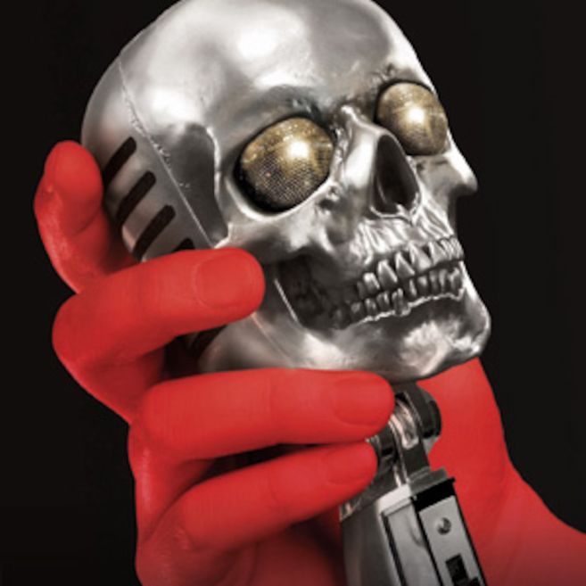 Eine rote Hand hält ein Mikrofon in Form eines silbernen Schädels.