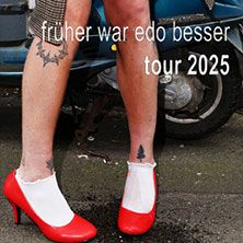 Person mit roten High Heels und Tattoos auf den Beinen vor einem Roller.