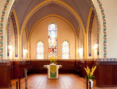 Innenansicht der Martinskirche mit Altar und bunten Glasfenstern.