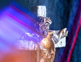 Nahaufnahme eines silbernen Altarkreuzes mit Lichteffekten in der Vicelinkirche.