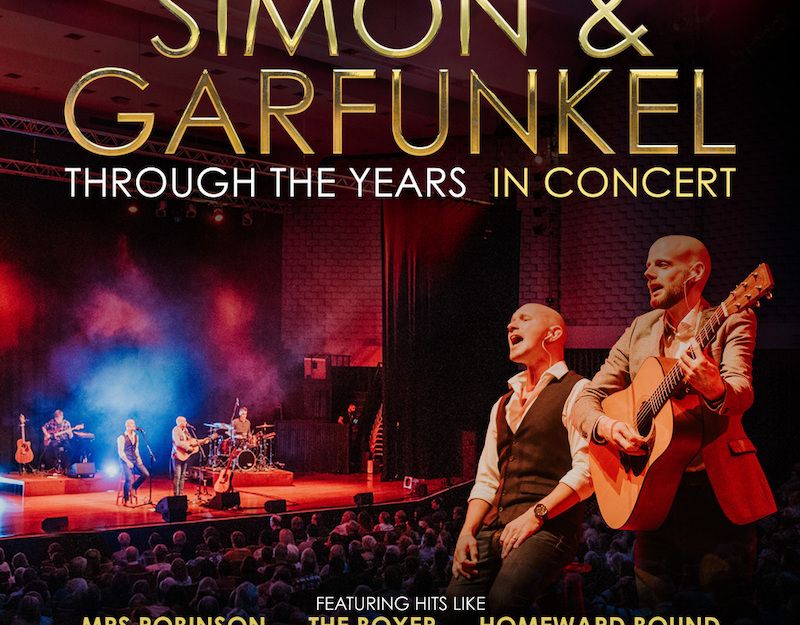 Konzertplakat für 'Simon & Garfunkel Through The Years' mit Band auf der Bühne und Gitarrist im Vordergrund.