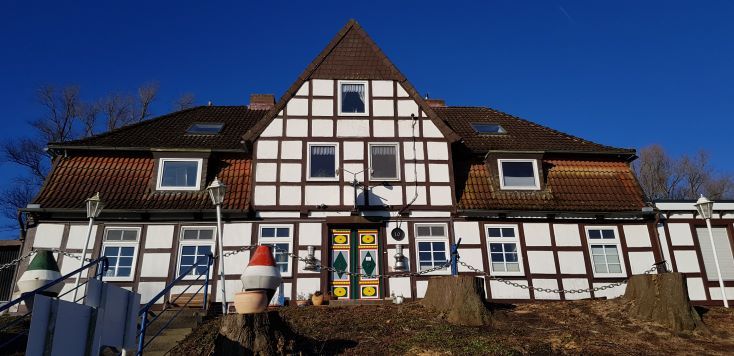 Fachwerkhaus mit bunten Türen und blauen Himmel im Hintergrund.