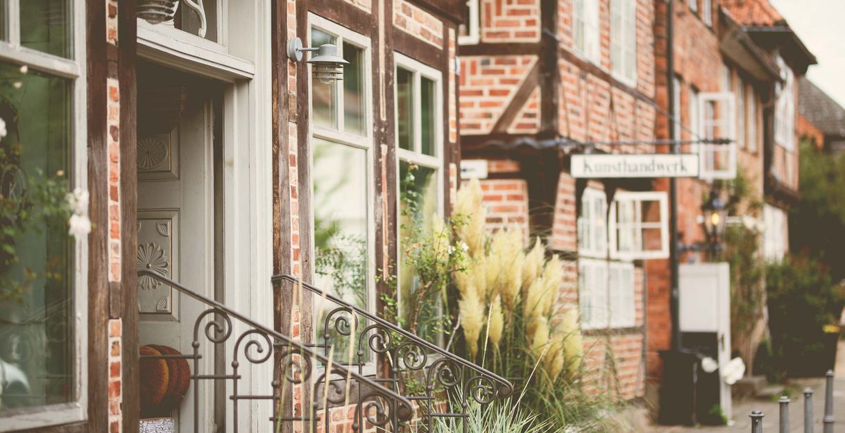 Fachwerkhäuser in der Altstadt von Eutin mit einem Schild für Kunsthandwerk.