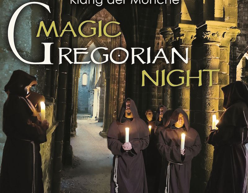 Mönche in Kutten mit Kerzen in einer gotischen Kirche.