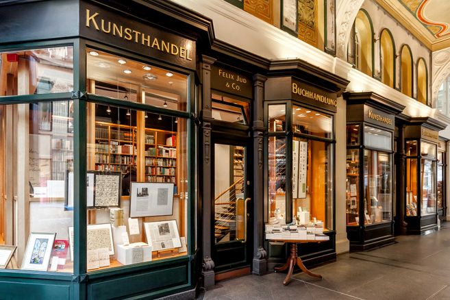 Eingang zur Kunstbuchhandlung Felix Jud mit Schaufenstern voller Bücher und Kunstwerke.