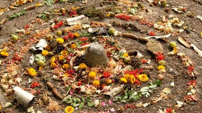 Künstlerischer Wirbel aus bunten Blumen auf Erdboden