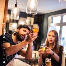 Zwei Personen beim Biertasting in einer Brauerei.