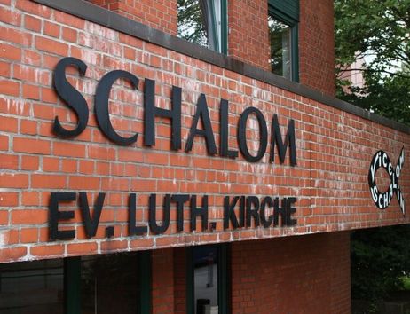 Backsteinfassade mit dem Schriftzug 'SCHALOM EV. LUTH. KIRCHE'.