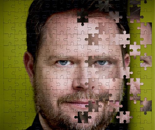 Plakatmotiv. Porträt Michael Frowin vor grünem Hintergrund als Puzzle. Auf der einen Seite sind die Puzzleteile falsch angeordnet und Teile seinens Gesichts befinden sich im Hintergrund oder an falscher Stelle.
