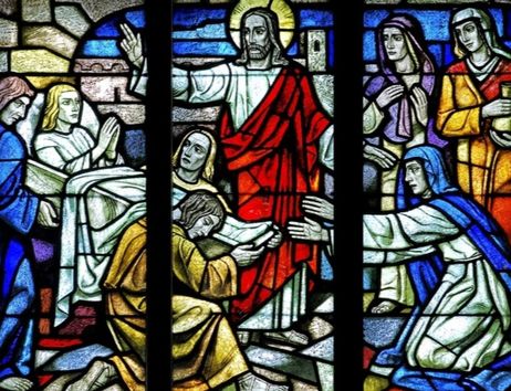 Buntglasfenster mit biblischer Szene in einer Kirche.