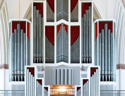 Große Kirchenorgel mit zahlreichen Pfeifen in einem Kirchenraum.
