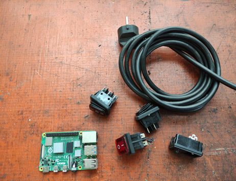 Stecker, Verlängerungsschnur und Platinen. Hintergrund ist rostorange.