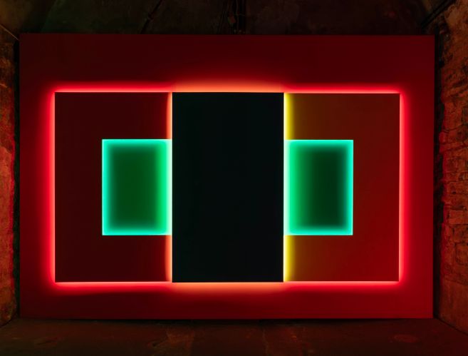 Abstrakte Neon-Installation im Museum gegenstandsfreier Kunst mit rotem Rahmen, dunkler Mittelachse und zwei türkis leuchtenden Rechtecken.