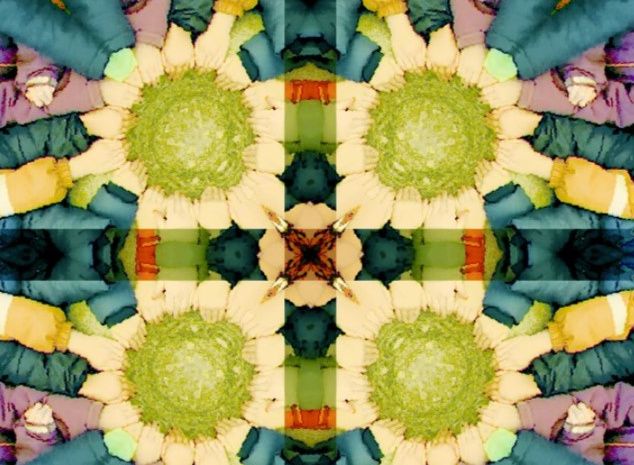 Ein kaleidoskopisches Bild mit bunten, symmetrisch angeordneten Formen und Farben, die an Blumen oder Mandalas erinnern.
