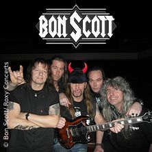Eine Rockband posiert mit einem Gitarristen, der Teufelshörner trägt. Im Hintergrund steht der Schriftzug 'Bon Scott'.
