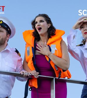 Drei Personen in Marineuniformen und Rettungsweste schauen in die Ferne.