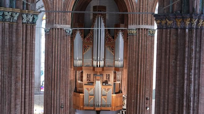 Große Orgel in einer Kirche zwischen zwei massiven Säulen.