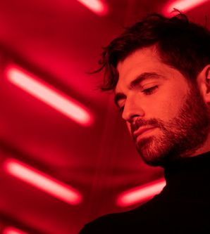 Person in rotem Licht mit nach unten gerichtetem Blick.