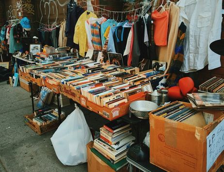 Ein Flohmarktstand mit Büchern, Kleidung und Schallplatten.