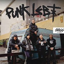 Band Swiss & Die Andern posiert vor einem blauen Wohnwagen mit Graffiti im Hintergrund. Schriftzug 'Punk lebt Tour 2026'.