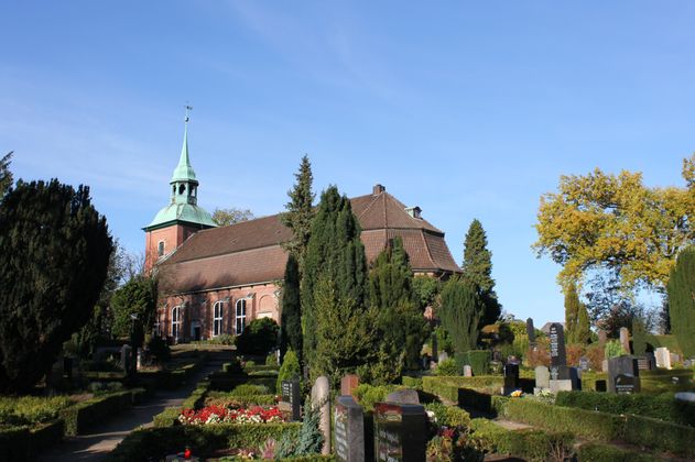 Kirche St. Pankratius in Ochsenwerder mit Friedhof im Vordergrund.