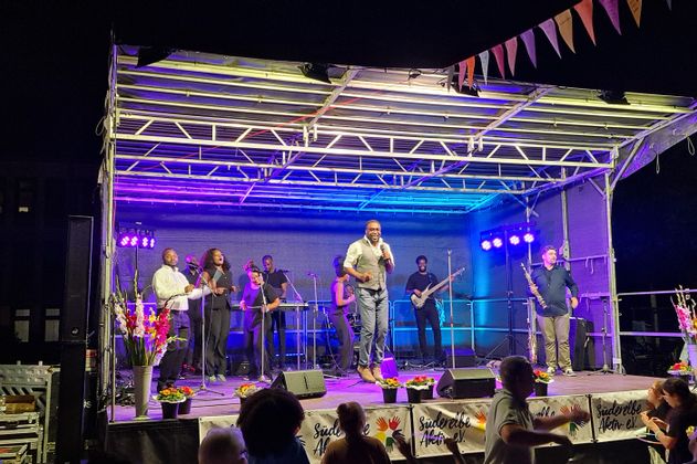 Afro Gospel Voices und Band auf der Bühne in Abendlicher Stimmung.