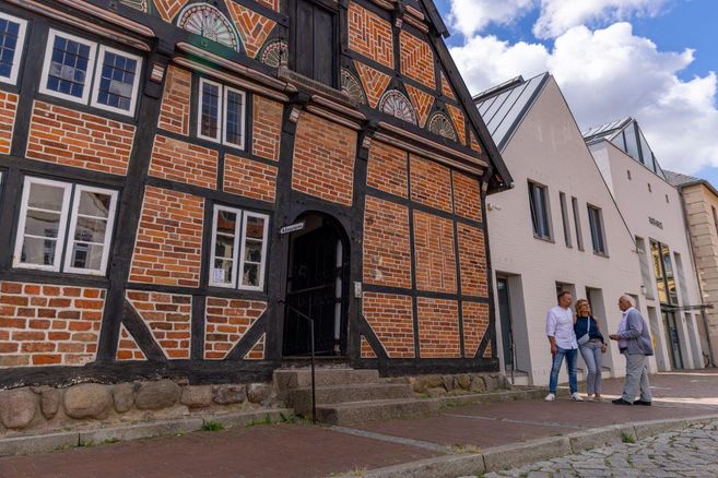 A person is going down a staircase overlooking a picturesque landscape. Colorful trees and houses can be seen in the distance.