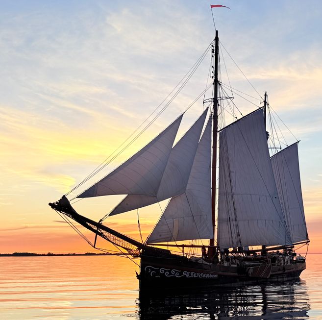Hier sieht man das Traditionssegelschiff FORTUNA mit allen gesetzten Segeln kurz vor dem Sonnenuntergang.