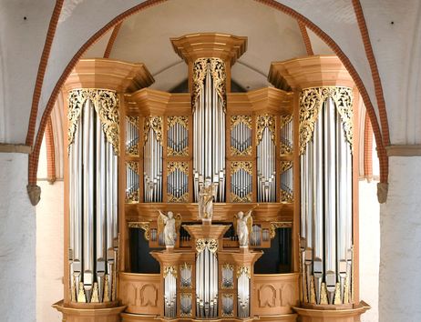 Eine prächtige Orgel mit goldenen Verzierungen und Pfeifen in einer Kirche.
