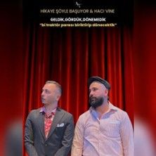 Zwei Männer vor einem roten Vorhang, einer im Anzug, der andere mit Mütze.