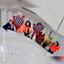 Gruppe von Menschen in bunter Kleidung auf einer Wendeltreppe.